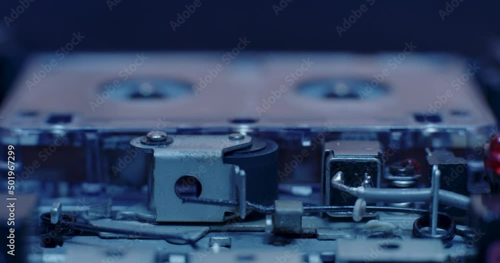 Exposed Internal Components Of Microcassette Recorder Playing Under Cold Blue Lighting Exposed Internal Components Of Microcassette Recorder Playing Under Cold Blue Lighting