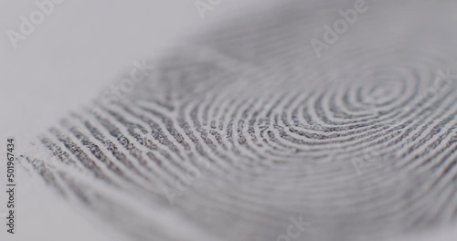 Extreme Close-Up Of Fingerprints On White Paper Being Slid Into And Out Of Focus photo