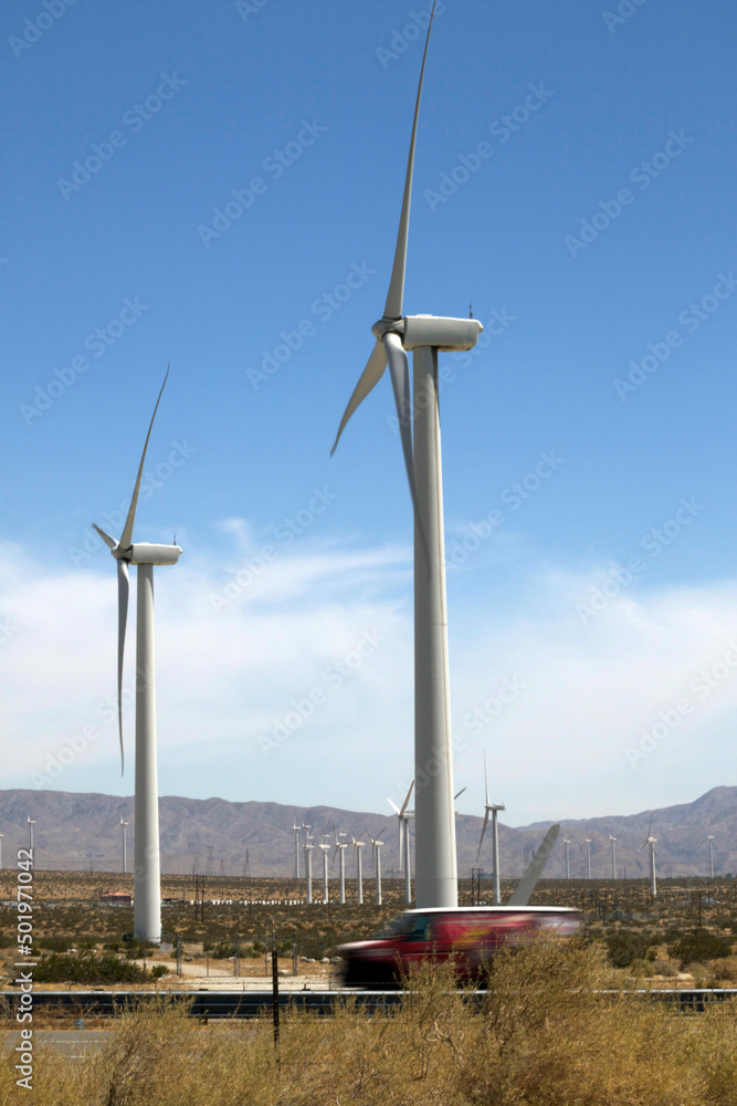 Large windmills in a clear blue sky against the backdrop of mountains Large windmills in a clear blue sky against the backdrop of mountains