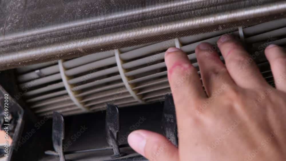 Worker cleaning dirty air conditioner blower fan and cooling coil. The blower of the dusty