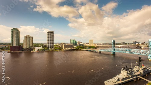 A Timelapse of clouds rolling across the St. Johns River in Downtown Jacksonville, Florida while boats race around the water and traffic crosses the bridges.