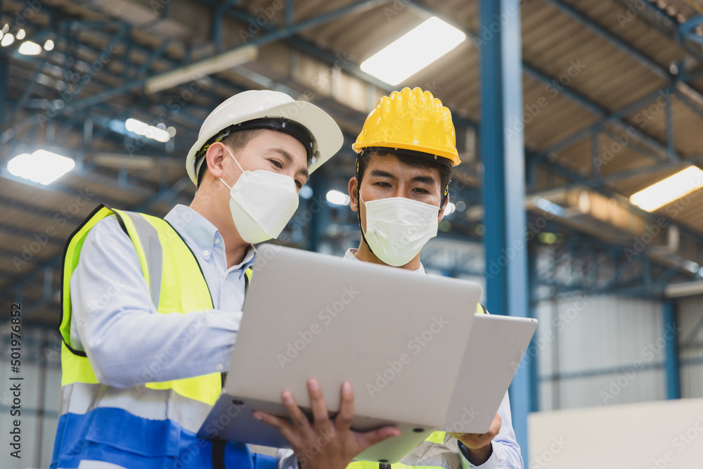 Manufacturing staff or worker in medical mask working together at factory Manufacturing staff or worker in medical mask working together at factory