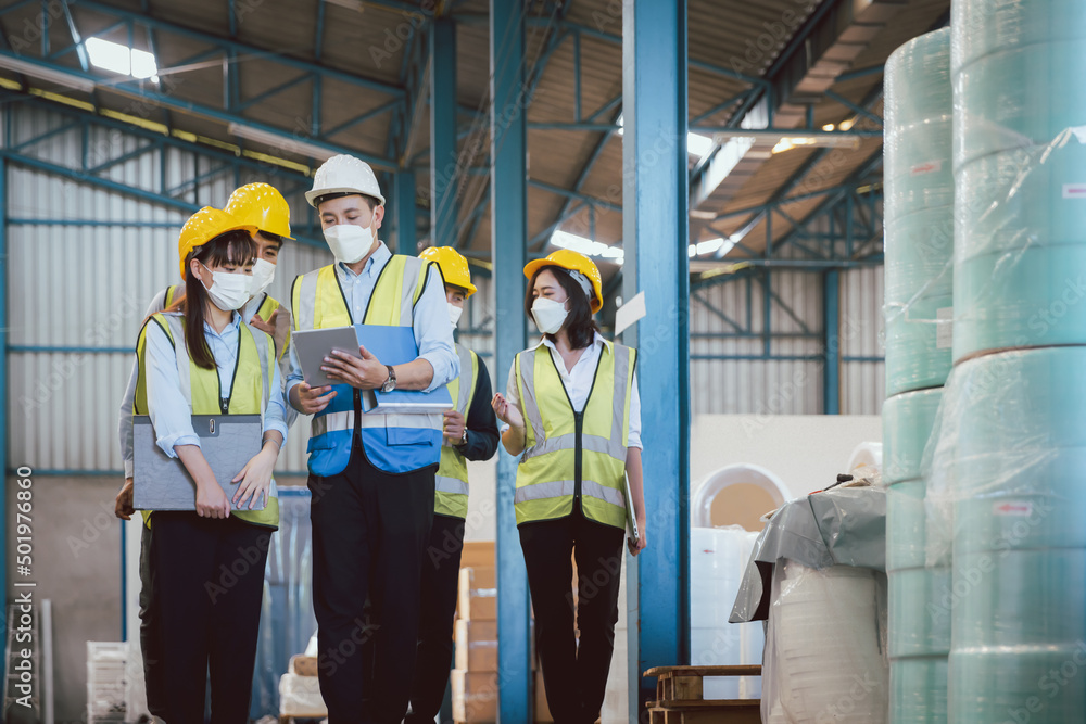 Manufacturing staff or worker in medical mask working together at factory Manufacturing staff or worker in medical mask working together at factory