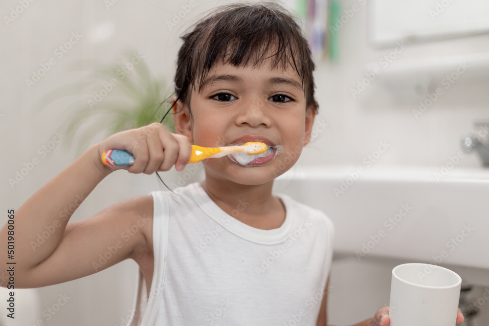 Little cute baby girl cleaning her teeth with a toothbrush in the bathroom Little cute baby girl cleaning her teeth with a toothbrush in the bathroom