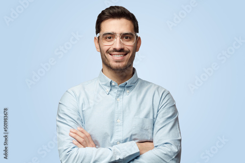 Attractive Caucasian man stands with arms crossed and plastic safety eyeglasses on