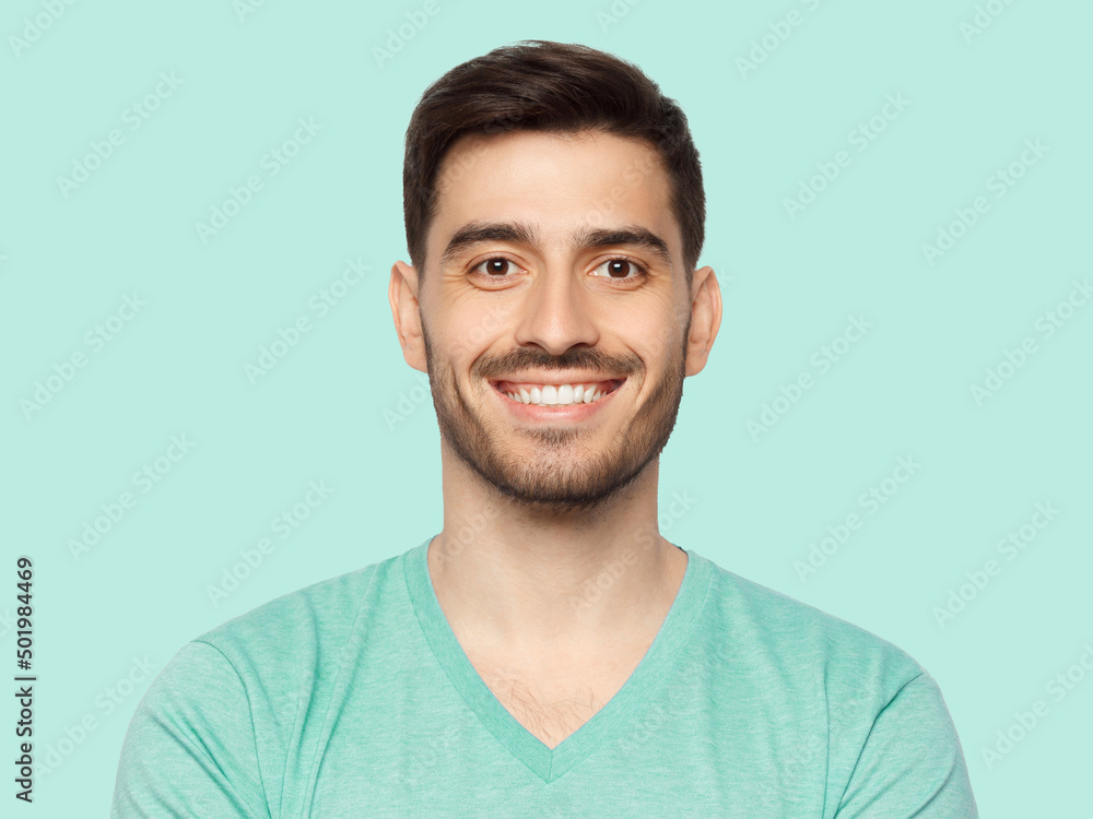 Fototapeta premium Portrait of young handsome smiling man, wearing casual mint blue t-shirt