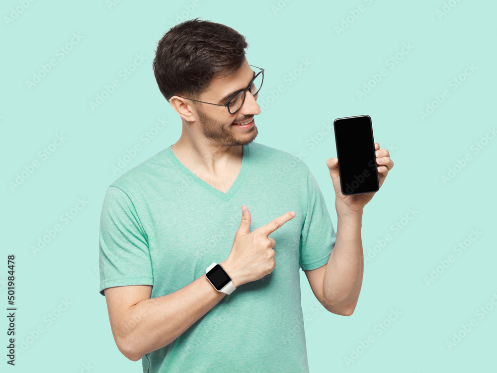 Happy man demonstrating blank phone and pointing to screen with finger Happy man demonstrating blank phone and pointing to screen with finger
