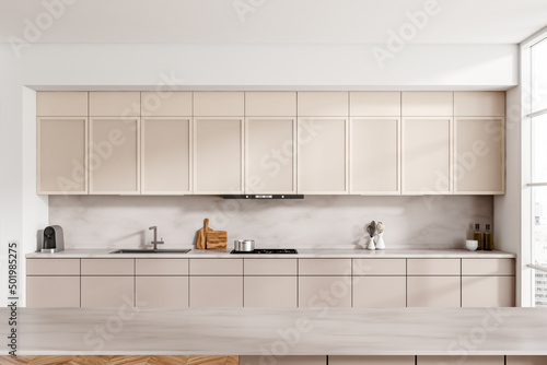 Light cooking interior with countertop, shelves and appliances, window