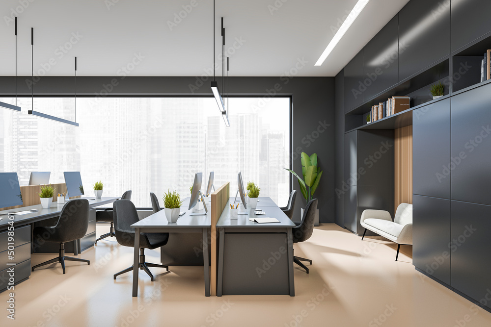 Side view on dark office interior with tables with desktops Side view on dark office interior with tables with desktops