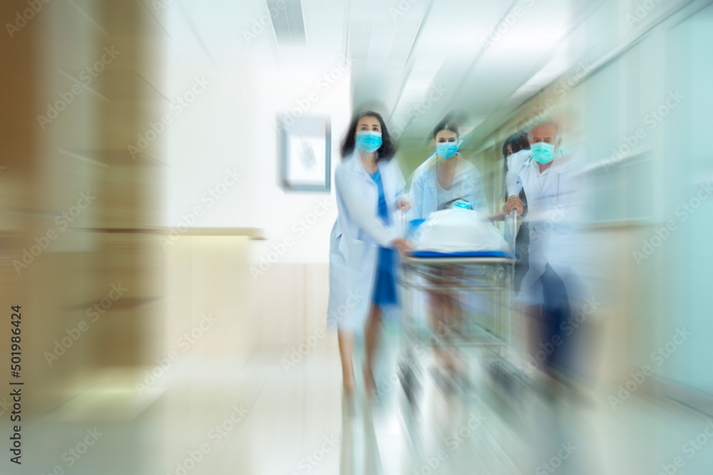 Blurred image of medical team pushing stretcher injured patient Seriously towards to Operating Room Blurred image of medical team pushing stretcher injured patient Seriously towards to Operating Room