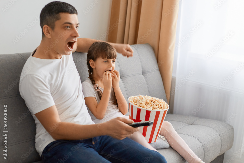 Portrait of young guy with widely opened mouth watching horror