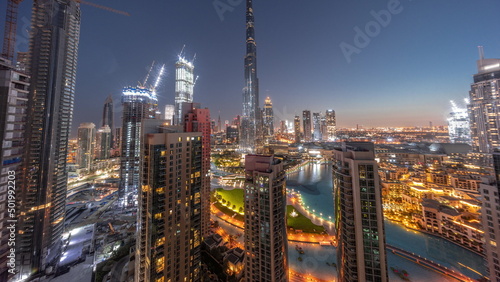 Dubai Downtown cityscape with tallest skyscrapers around aerial night to day timelapse. © neiezhmakov
