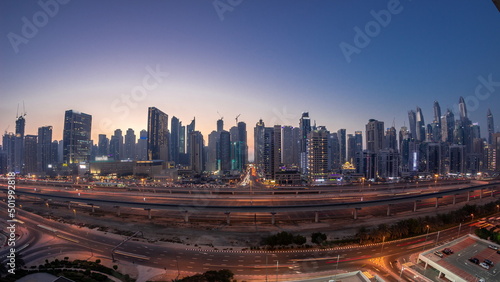 Panorama of Dubai Marina skyscrapers and Sheikh Zayed road with metro railway aerial day to night timelapse, United Arab Emirates