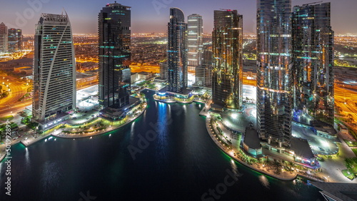 Fototapeta Naklejka Na Ścianę i Meble -  Tall residential buildings at JLT aerial night to day timelapse, part of the Dubai multi commodities centre mixed-use district.