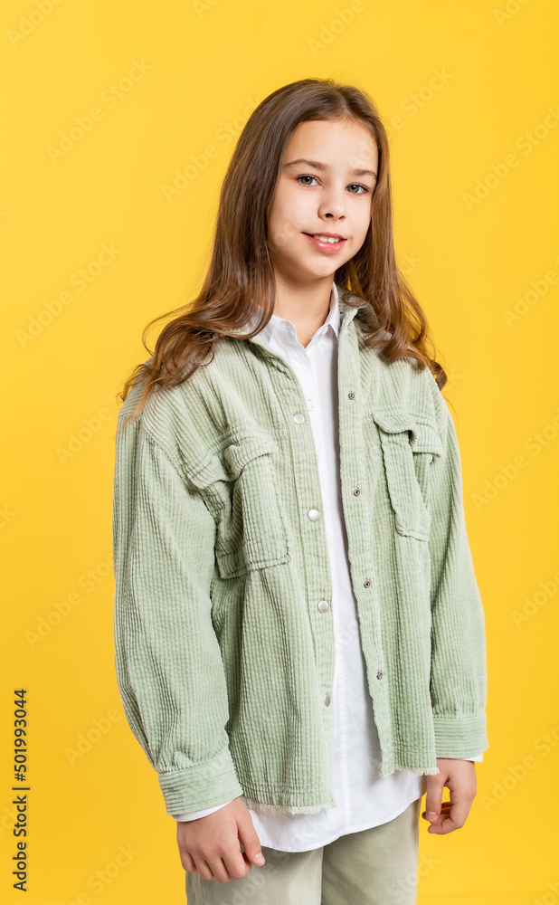 portrait of a beautiful girl in a green denim jacket and white shirt with loose hair. on a red background. portrait of a beautiful girl in a green denim jacket and white shirt with loose hair. on a red background.