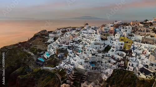 Beautiful sunset skyline view in Oia town on Santorini island, Greece. Traditional white architecture and greek orthodox churches © SASITHORN