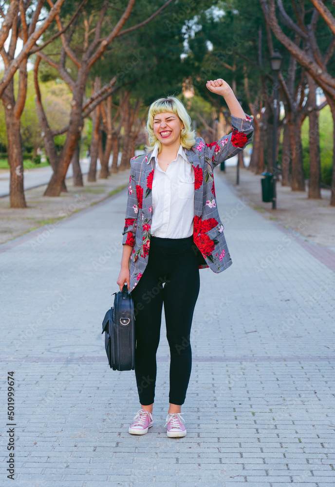 El éxito en la vida laboral , celebración al conseguir las metas y objetivos, mujer feliz con una mano levantada y un maletín en la mano El éxito en la vida laboral , celebración al conseguir las metas y objetivos, mujer feliz con una mano levantada y un maletín en la mano