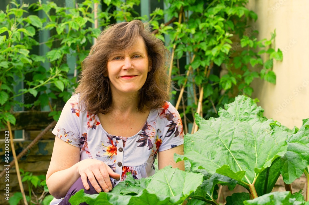 Woman amongst the rhubarb and raspberries. Woman amongst the rhubarb and raspberries.