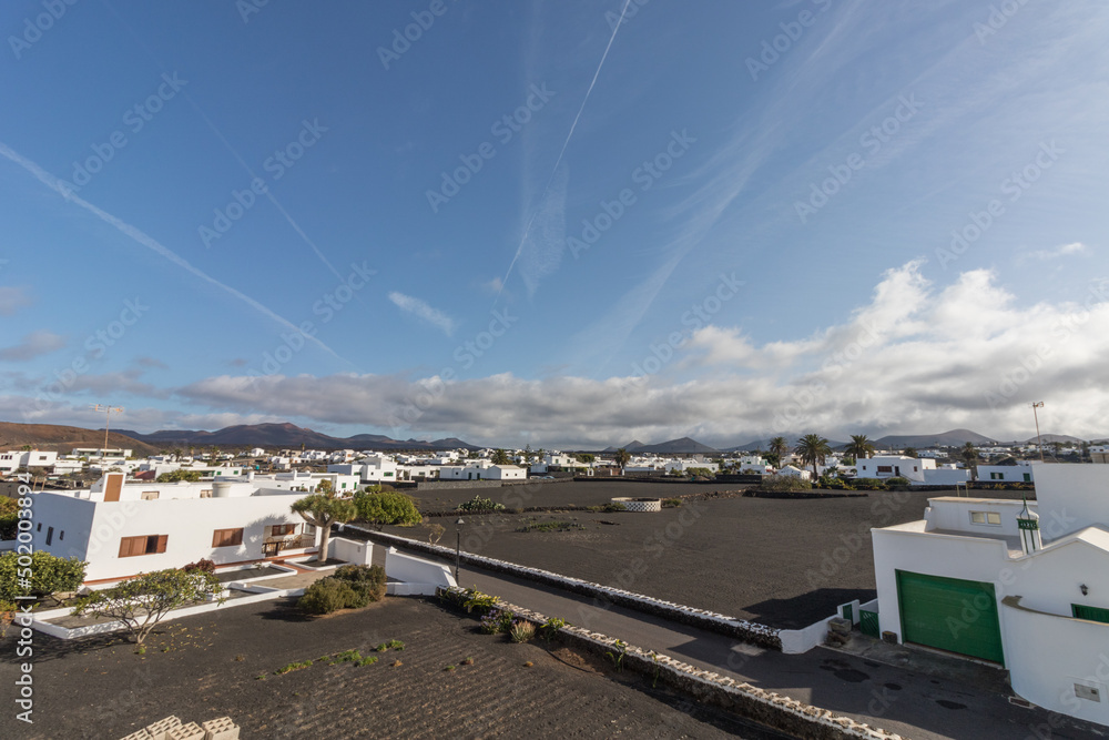Arial view of Yaiza a white town with black soil with the volcanoes on Timanfaya Park on the background in Lanzarote, Canary Islands in Spain