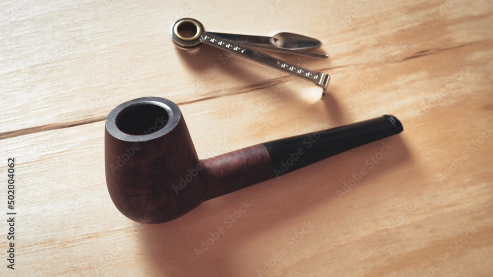 Smoker's Accessory. Wooden smoking pipe on the table