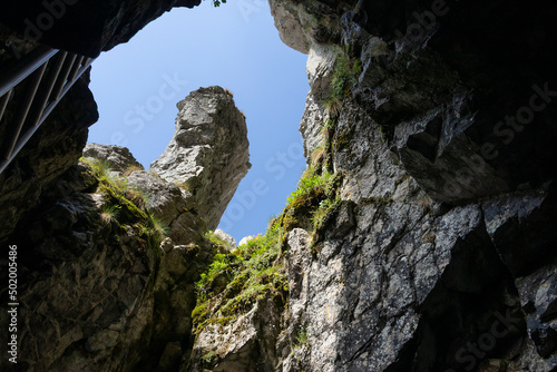 Entrance and exit from the Raptawicka Cave in the Kościeliska Valley. The hole is equipped with chains and a ladder. The cave is located in Raptawicka Turnia, close to the Mylna and Obłazkowa caves.