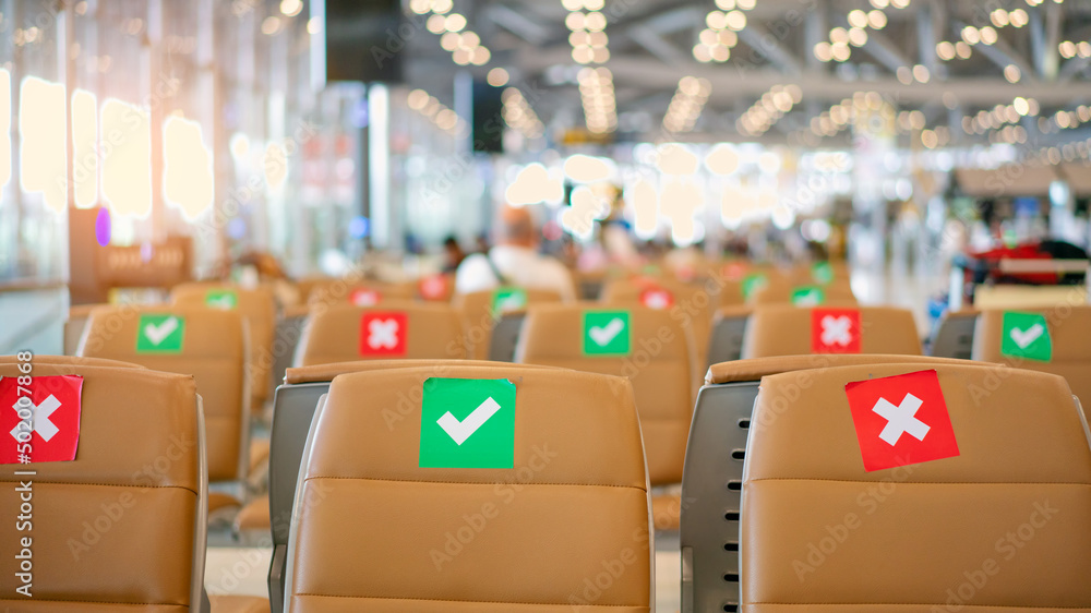 View of sign mark on seats in airport terminal for social distancing campaign during outbreak of Covid 19 View of sign mark on seats in airport terminal for social distancing campaign during outbreak of Covid 19
