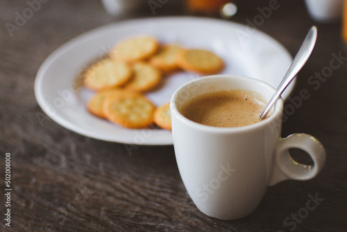 Hot coffee with crackers on wooden table