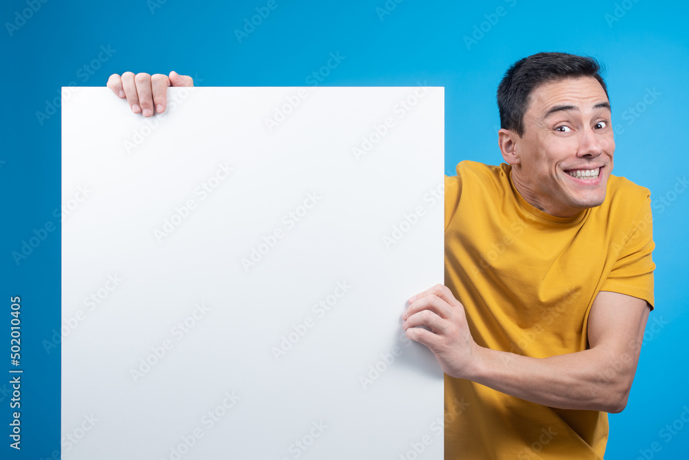 Excited man showing blank banner in studio Excited man showing blank banner in studio