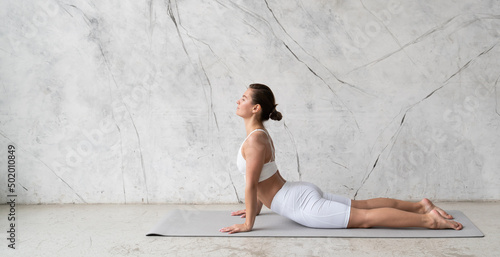 Banner of young flexible woman practicing yoga upward facing dog, urdhva mukha svanasana photo