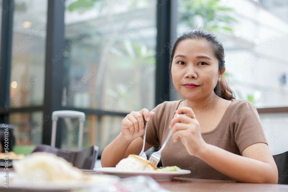 close up young asian woman hold spoon and fork prepare to eat breakfast or brunch in hotel for lifestyle concept