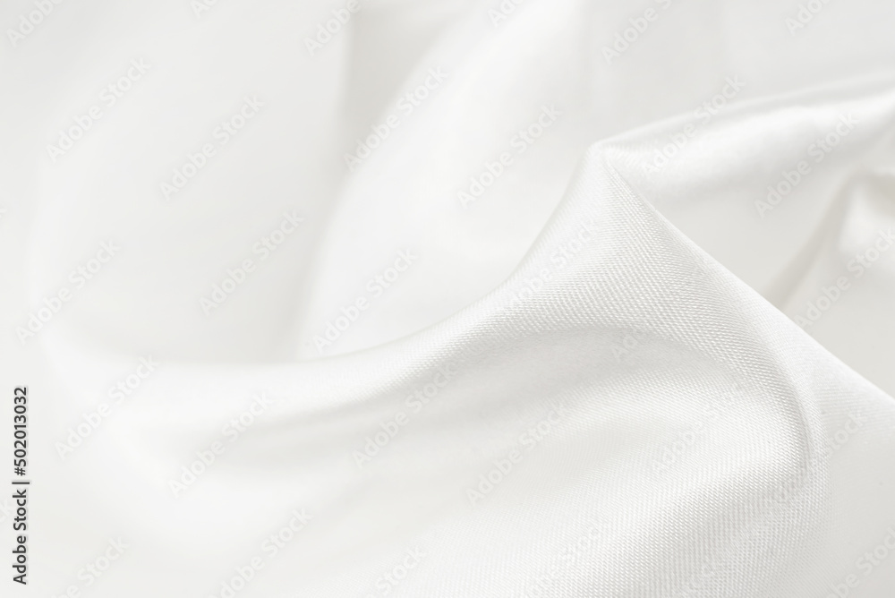A twisted piece of white fabric. White material or texture with waves and folds. Wrinkled white fabric A twisted piece of white fabric. White material or texture with waves and folds. Wrinkled white fabric