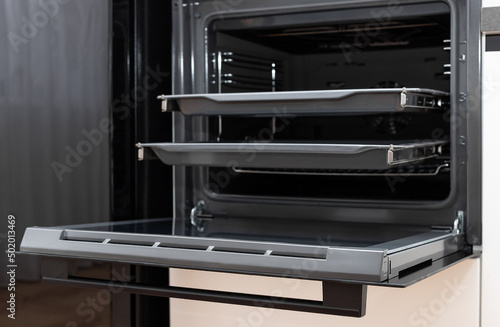 new electric oven built in with trays on telescopic rails. Modern kitchen furniture. selective focus. closeup