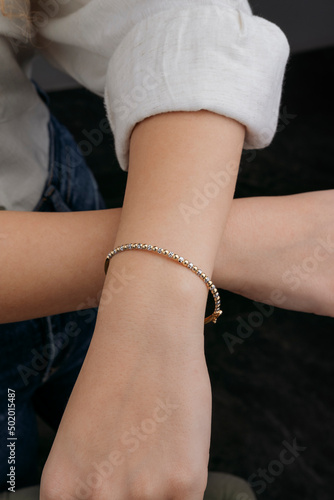 women's gold bracelet on the girl's hand, women's accessories, jewelry, gold bracelet with stones, women's jewelry, a girl with a bracelet on her arm, a bracelet with stones