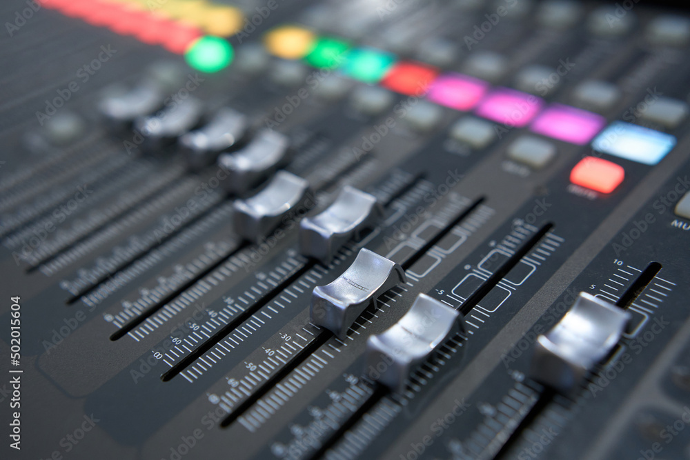 Professional audio mixing console. Mixer. Pro audio mixing board faders and knobs. Static shot of multi-track music recording equipment faders and sliders. Professional audio mixing console. Mixer. Pro audio mixing board faders and knobs. Static shot of multi-track music recording equipment faders and sliders.