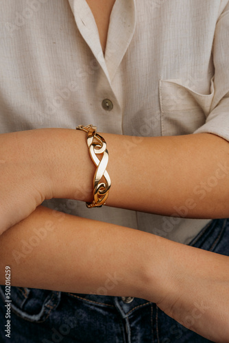 women's gold bracelet on the girl's hand, women's accessories, jewelry, gold bracelet with stones, women's jewelry, a girl with a bracelet on her arm, a bracelet with stones