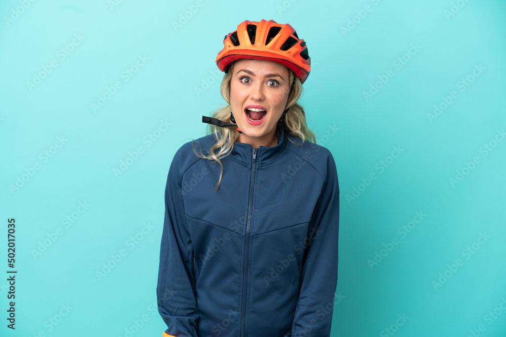Young cyclist woman isolated on blue background with surprise facial expression Young cyclist woman isolated on blue background with surprise facial expression