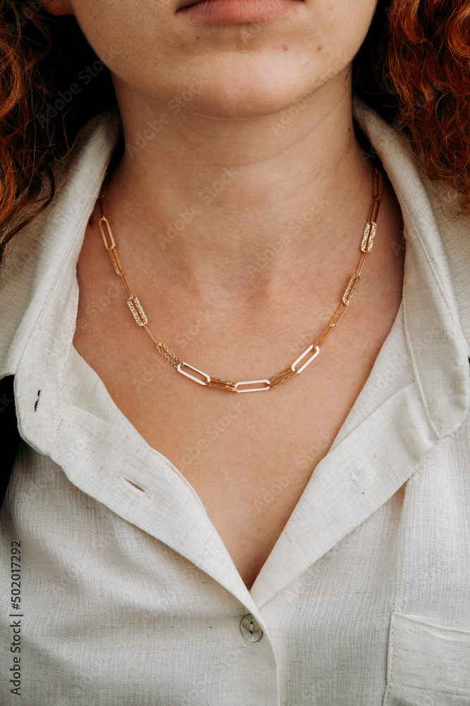 Close-up young woman wearing gold chain necklace. Modern fashion details. minimalist lifestyle