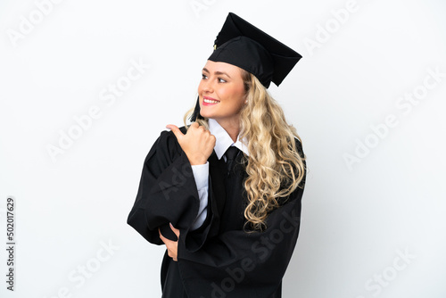 Young university graduate woman isolated on white background pointing to the side to present a product
