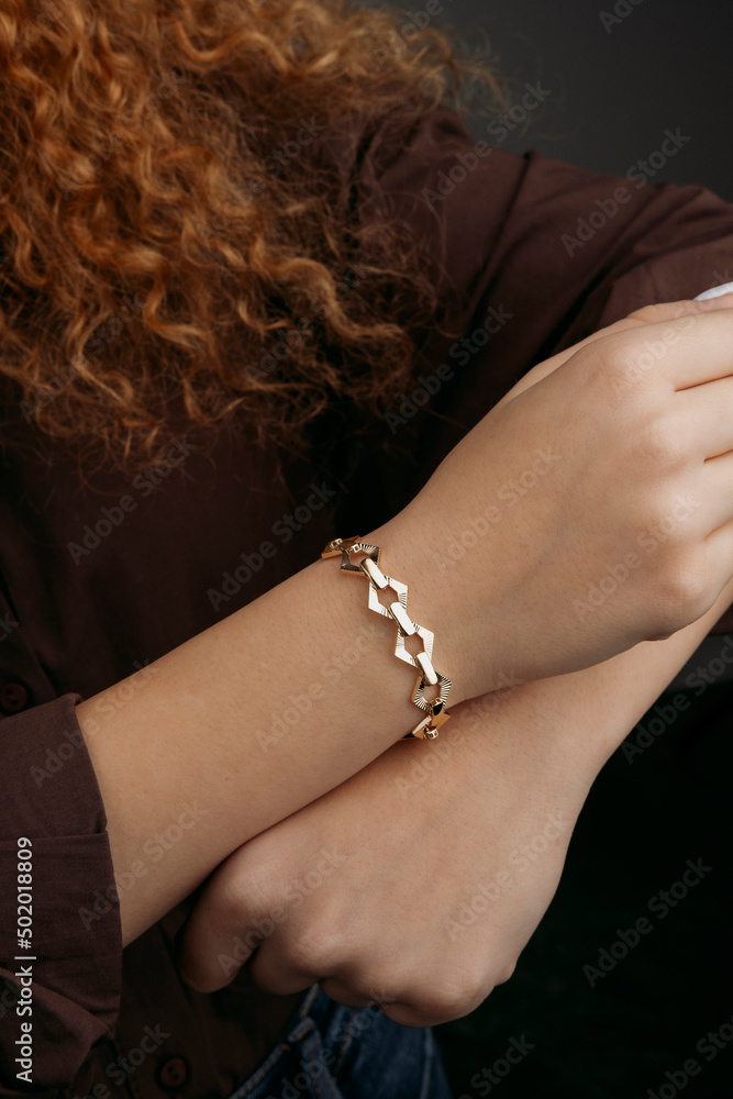 women's gold bracelet on the girl's hand, women's accessories, jewelry,  gold bracelet with stones, women's jewelry, a girl with a bracelet on her  arm, a bracelet with stones Stock Photo | Adobe