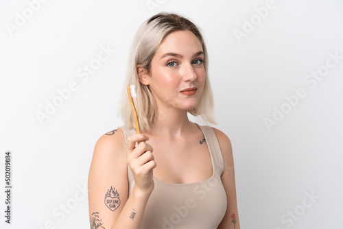 Young caucasian woman isolated on white background with a toothbrush