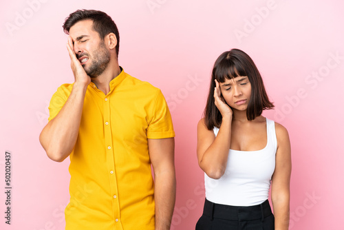 Young couple isolated on pink background unhappy and frustrated with something