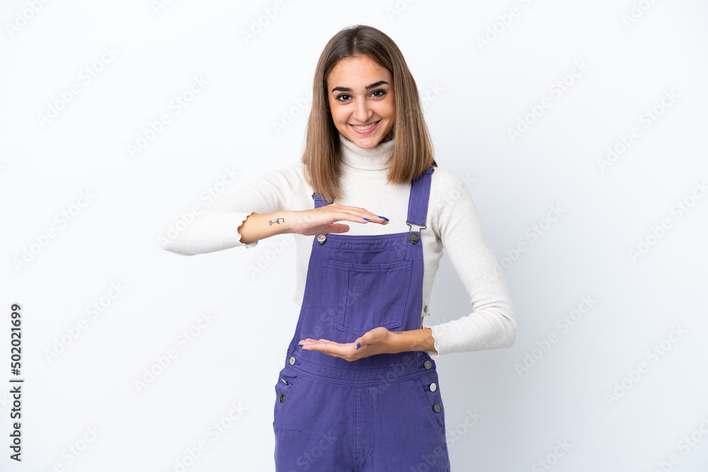 Young caucasian woman isolated on white background holding copyspace imaginary on the palm to insert an ad Young caucasian woman isolated on white background holding copyspace imaginary on the palm to insert an ad