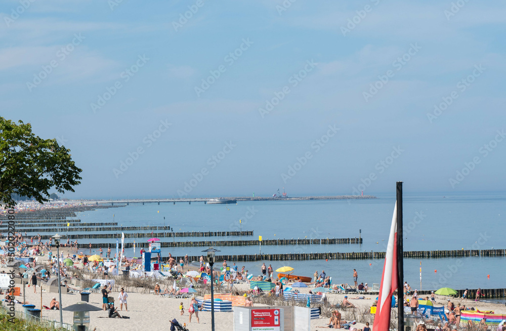 wakacje ludzie odpoczywają latem na plaży w Kołobrzegu - obrazy, fototapety, plakaty 