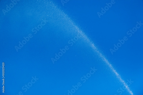 Water jet spraying on blue sky