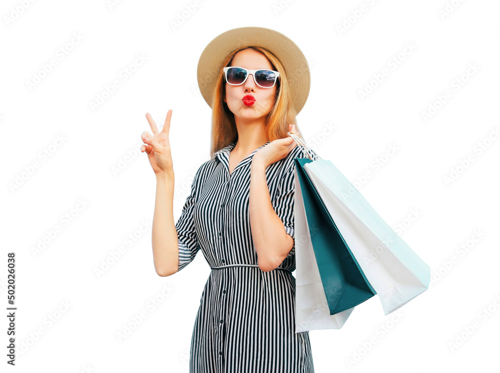Portrait of beautiful woman blowing her lips with shopping bags wearing a summer straw round hat, black white striped dress isolated on white background Portrait of beautiful woman blowing her lips with shopping bags wearing a summer straw round hat, black white striped dress isolated on white background