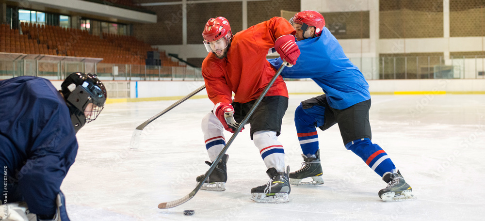 Fototapeta premium Hockey players playing hockey in the ice rink in winter 