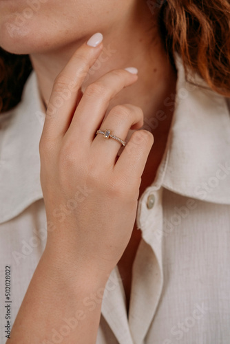 Golden Ring on a female hand  diamonds Diamond ring in hands of young lady. Close-up photo shoot