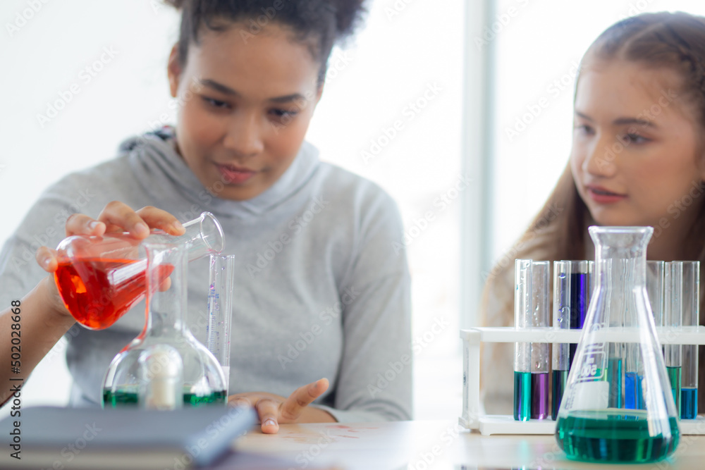 Young teacher teaching group student about science and test chemical for liquid in the lab of school, children studying and learning experiment science in the laboratory, education concept. Young teacher teaching group student about science and test chemical for liquid in the lab of school, children studying and learning experiment science in the laboratory, education concept.