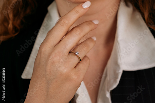 Golden Ring on a female hand, diamonds Diamond ring in hands of young lady. Close-up photo shoot