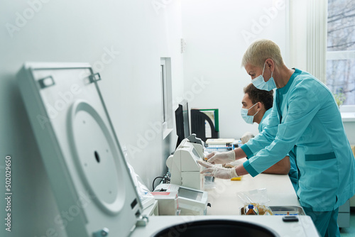 Man and woman working with gadgets in hospital laboratory